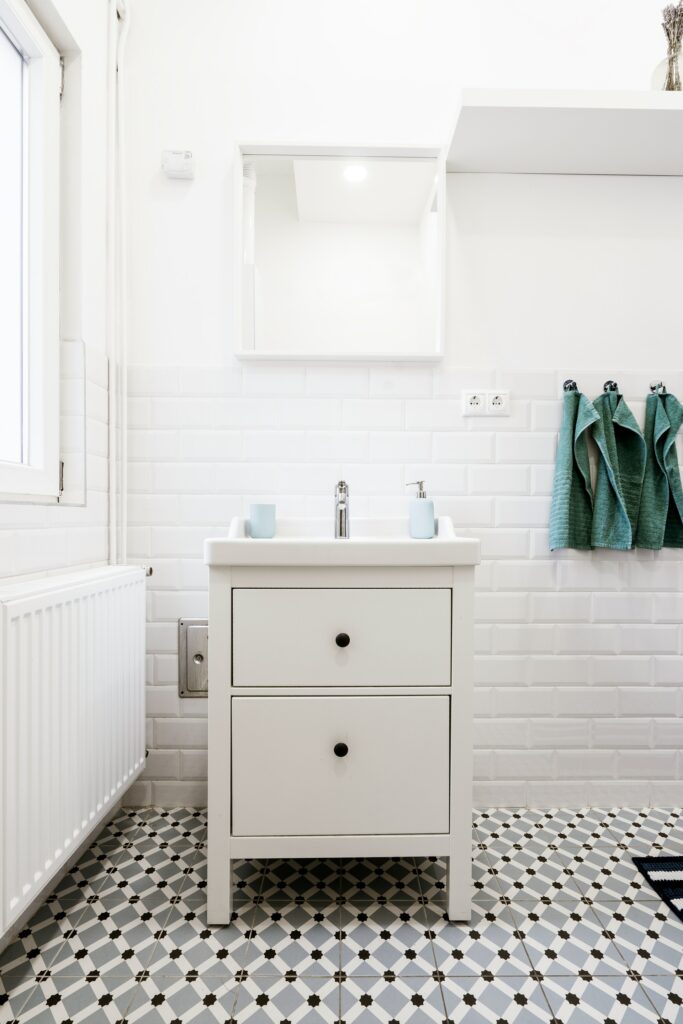 Small white bathroom with feature floor panels and a pedestal sink.