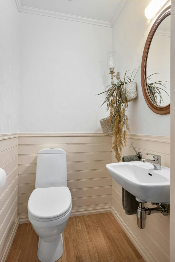 Small bathroom with a trough sink and bathroom wall panels.