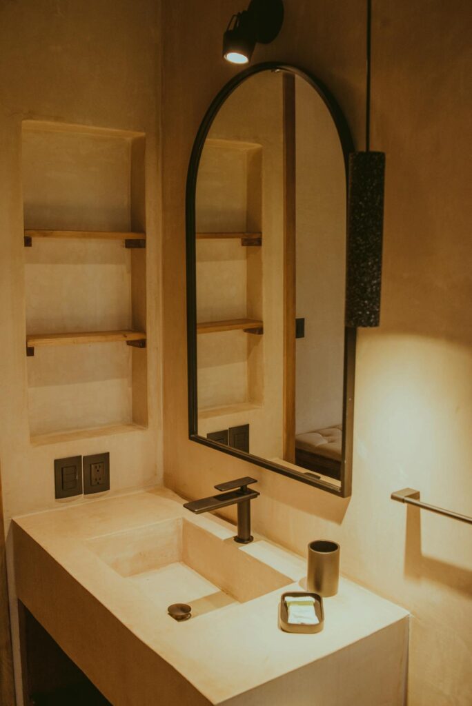 Small bathroom with a recessed shelf and a mirror.
