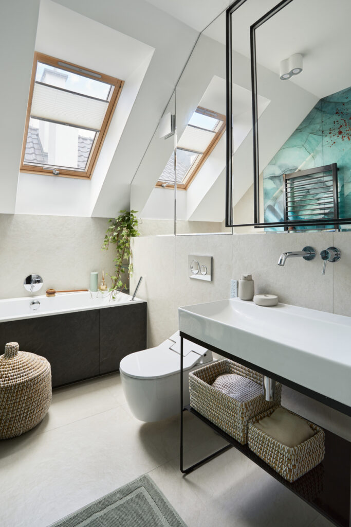 Stylish bathroom design with panels painted in green on the wall. Bathtub, towels, rattan baskets and other personal accessories. Glamour interior concept. Template.