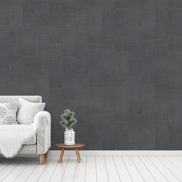 A living room with brushed carbon wall panels, a light grey couch and a low wooden side table with Christmas decor.