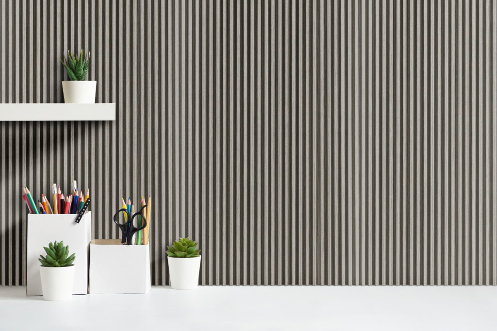 White desk with stationary containers and succulents underneath a floating shelf that is mounted on grey oak wall panelling.