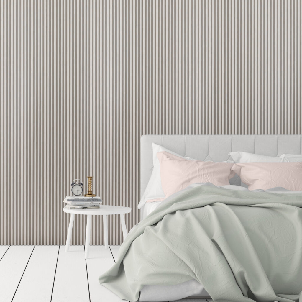 White bedroom interior with light grey oak slat wall panelling and pastel green and pink bed coverings.