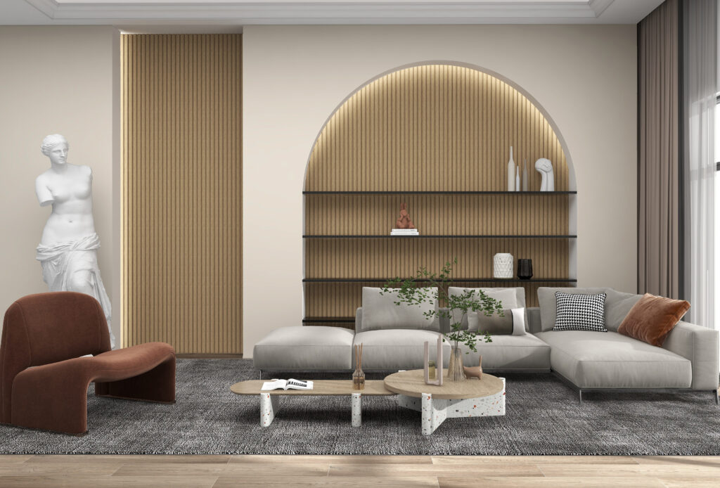 A living room, decorated in warm-toned colours, sculptured artwork and recessed arched shelving. A large grey couch in front of the shelving, with a coffee table and armchair off to the side.