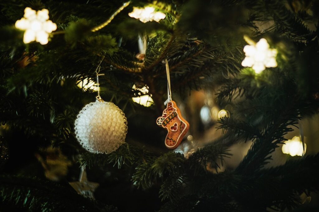 Faux Christmas tree with star-shaped lights, a round white bauble and a stocking-shaped gingerbread bauble.