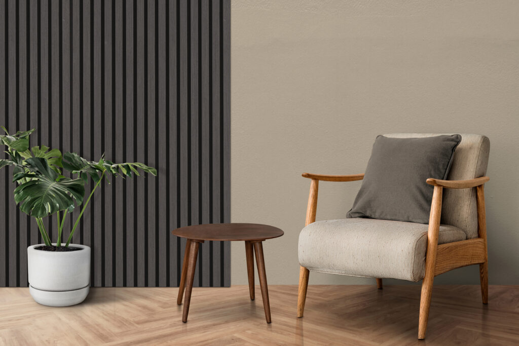 Sitting area with warm wood furniture, a potted monstera, wood-effect chevron flooring and charcoal wood-effect wall panelling.
