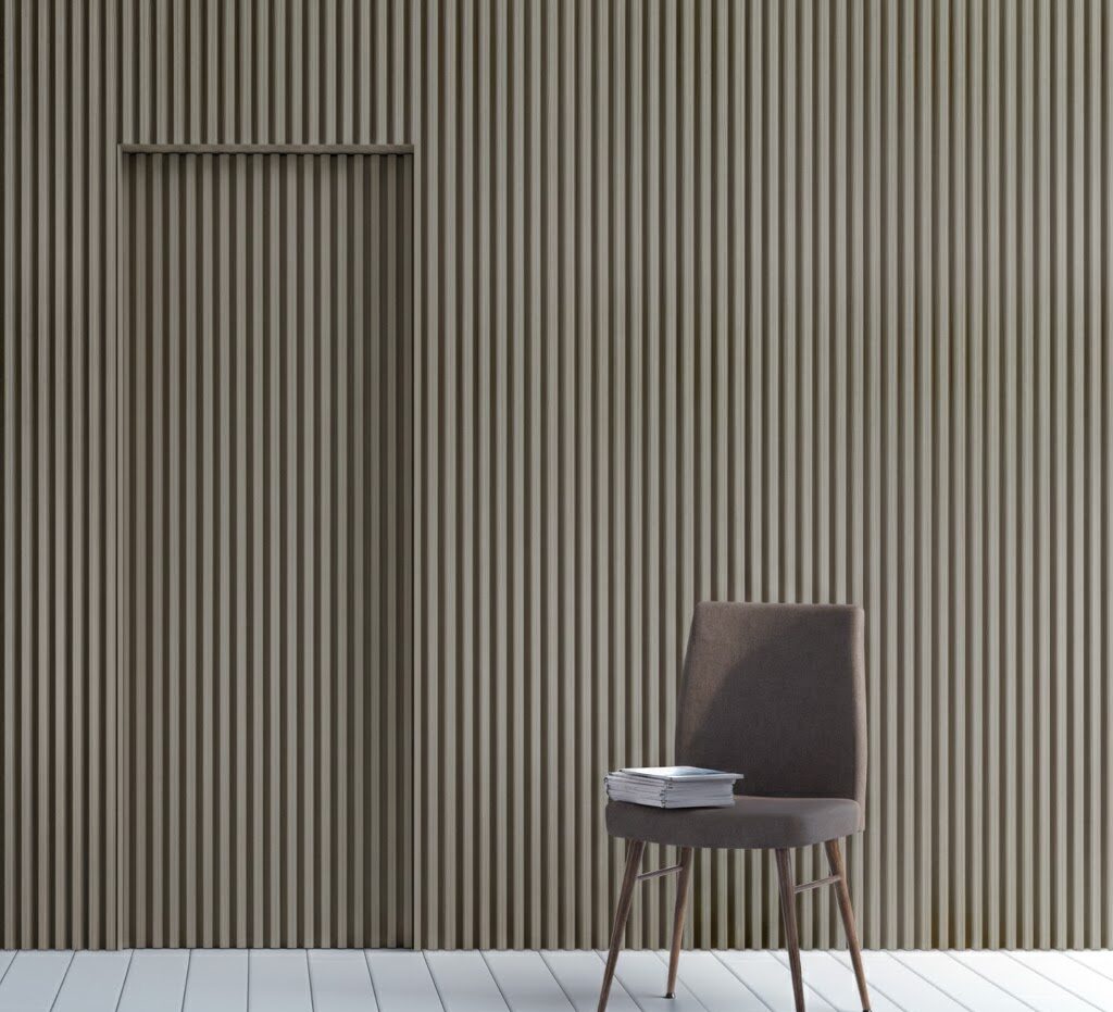 Oak slat wall with hidden door that is slightly ajar. The wall panelled room is behind an ashy brown chair with some books on it.